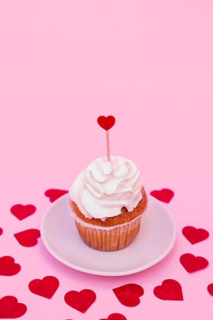 Tasty cake with whip between decorative hearts