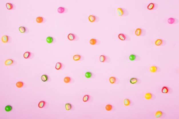 Tasty candies on pink background