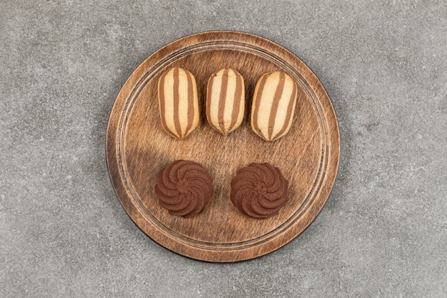 Tasty cocoa cookies on wooden board.