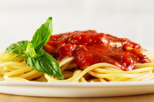 Free photo tasty colorful appetizing cooked spaghetti italian pasta with tomato sauce bolognese and fresh basil. closeup.