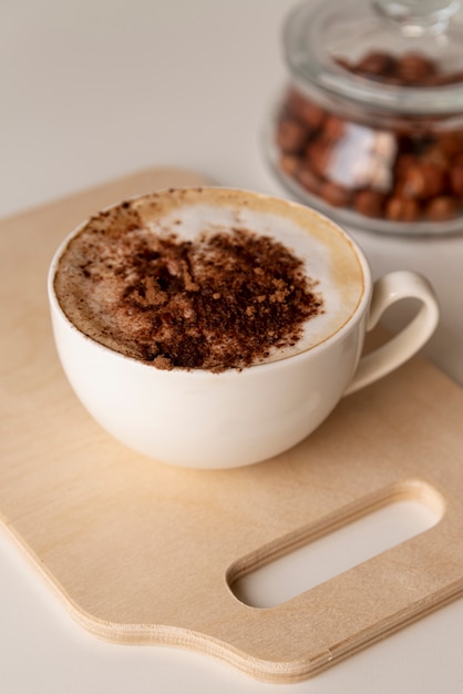 Tasty cup of coffee on wooden board