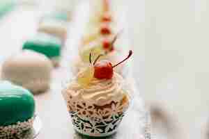 Free photo tasty cupcake with cream and redberry on the candybar