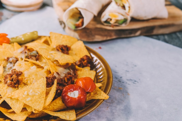 Free photo tasty delicious mexican yellow nachos chips in brown plate