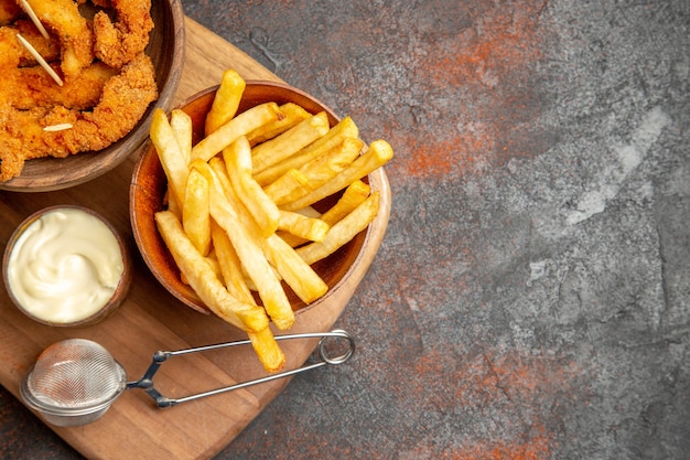 Tasty dinner with crispy fried chicken and potatoes with mayonnaise and ketchup