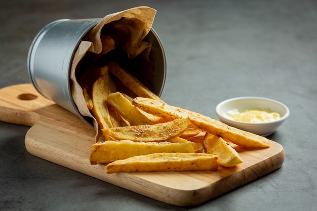 Tasty french fries on on dark background