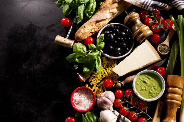 Tasty fresh appetizing italian food ingredients on dark background. 