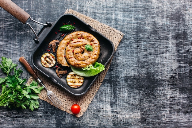 Free photo tasty grilled spiral sausages for meal on gray wooden background