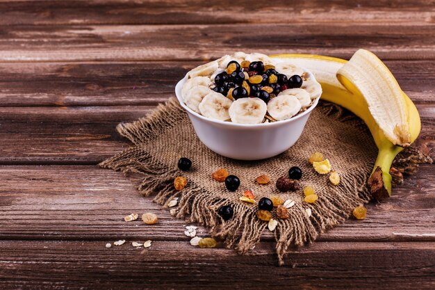 Tasty healthy morning breakfast made of milk and porridge with nuts, bananas and honey