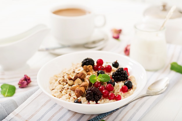 Tasty and healthy oatmeal porridge with berry, flax seeds and nuts. Healthy breakfast. Fitness food. Proper nutrition.