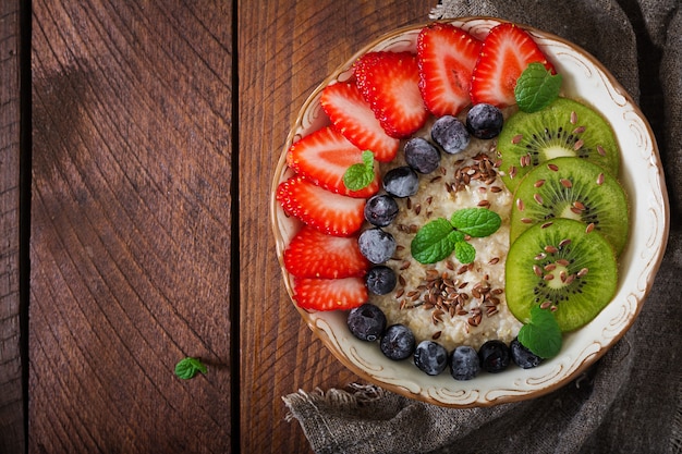 Tasty and healthy oatmeal porridge with fruit, berry and flax seeds. Healthy breakfast. Fitness food. Proper nutrition. Flat lay. Top view