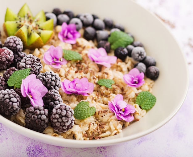 Free Photo tasty and healthy oatmeal porridge with fruit, berry and flax seeds. healthy breakfast. fitness food. proper nutrition.