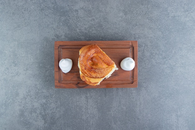 Free photo tasty homemade pastry and cream on wooden board.