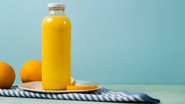 Tasty juice bottle and oranges