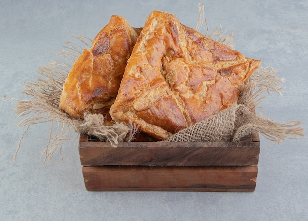 Tasty khachapuri pastries in wooden box. 