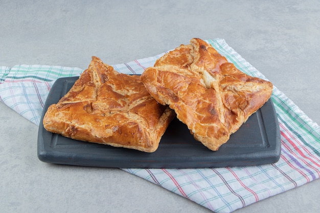 Tasty khachapuri pastry on dark board. 