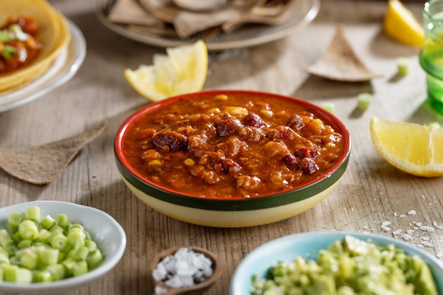 Tasty mexican food with fresh avocado sauce burittos tacos chilli con carne on wooden table