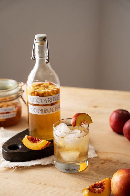 Tasty nectarine kombucha  bottle on table