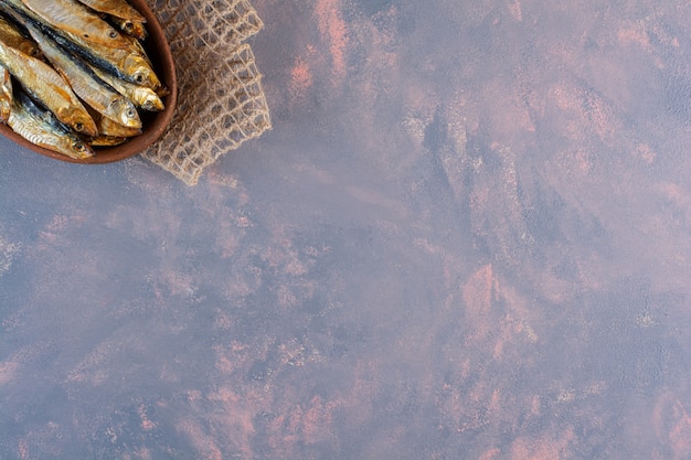 Tasty salted fish on a wooden plate on the marble surface