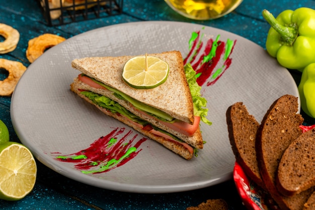 tasty sandwich with green salad ham and tomatoes as a filling on blue