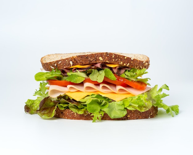 Tasty sandwich with vegetables, ham and cheese