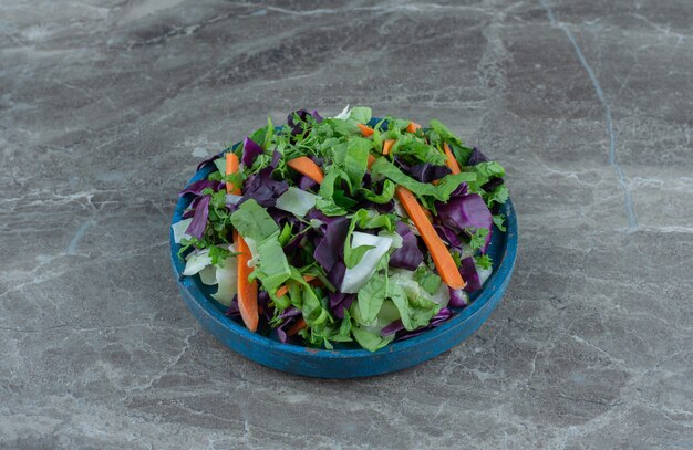 Tasty sliced vegetables in a bowl , on the marble table. 