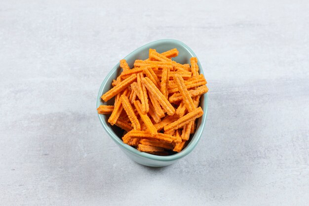 Tasty stick chips in blue bowl.