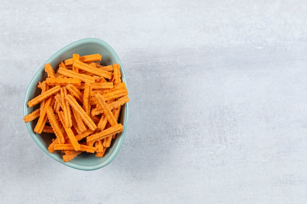 Tasty stick chips in blue bowl.