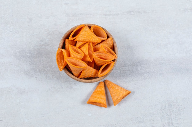 Tasty triangle chips in wooden bowl.