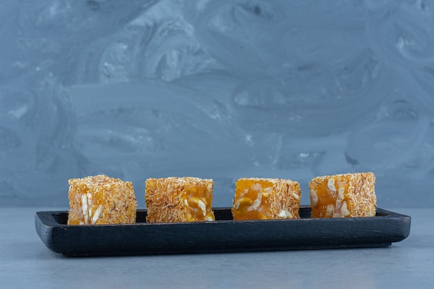 Tasty Turkish delight flavors on a wooden board, on the tea towel, on marble table