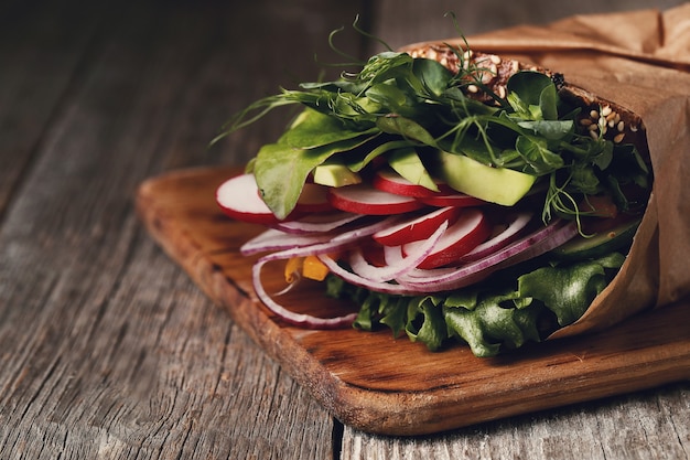 Tasty vegan sandwich over wooden table