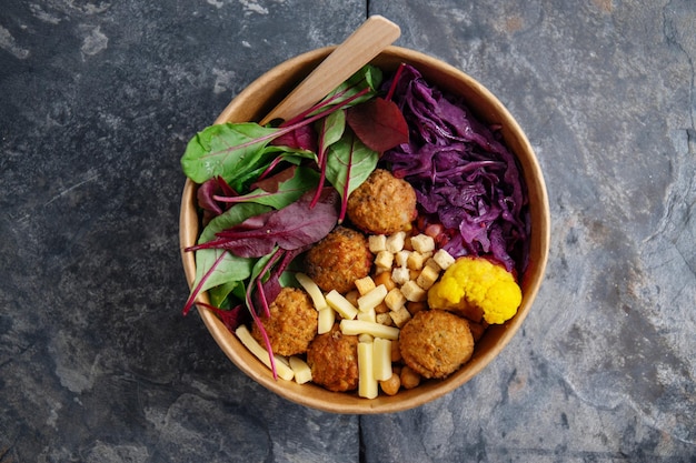 Tasty vegan vegetarian salad with chickpea falafel and leaves served in paper bowl Healthy life or zero waste concept