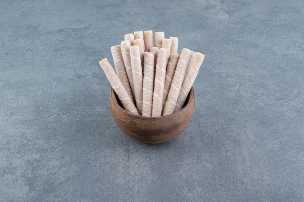 Tasty wafer rolls in wooden bowl.  