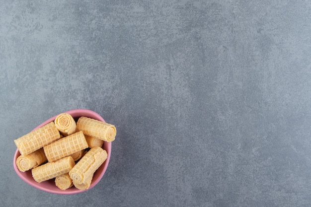 Free photo tasty waffle rolls in pink bowl.