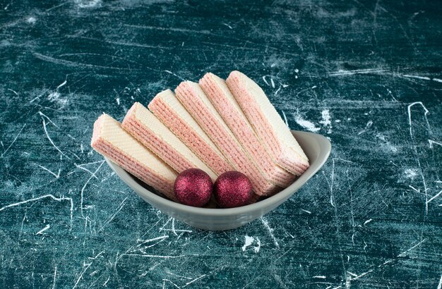 Tasty waffles with Christmas shiny balls in a white plate. High quality photo