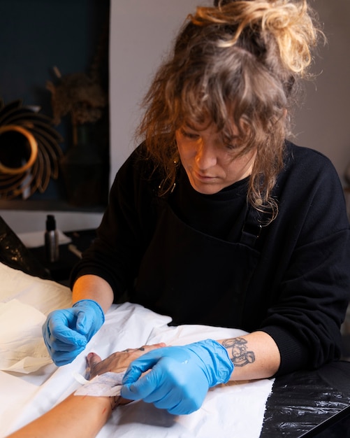 Tattoo artist wearing gloves high angle