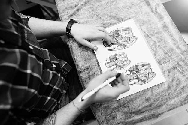 Free photo tattoo master preparing sketch for tattoo