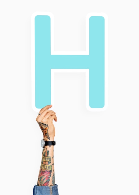 Free photo tattooed hand holding h sign, isolated on white