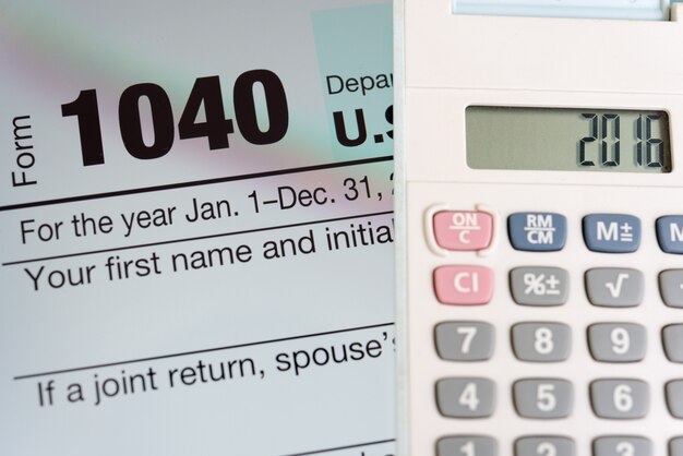 Tax form on tablet screen and calculator
