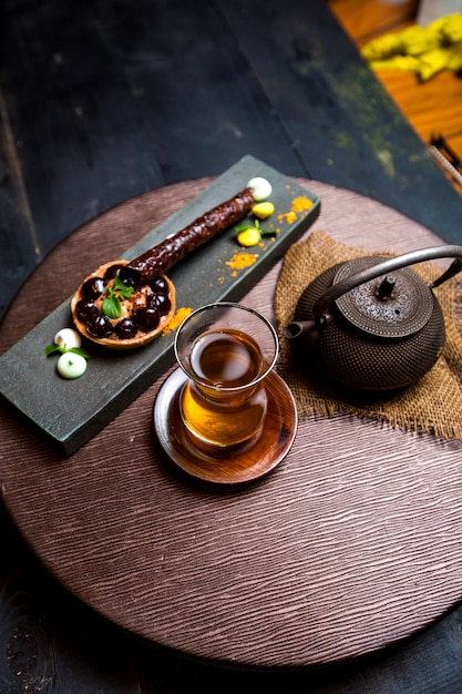 Tea in armudu glass, chinese teapot and chocolate tartaleta