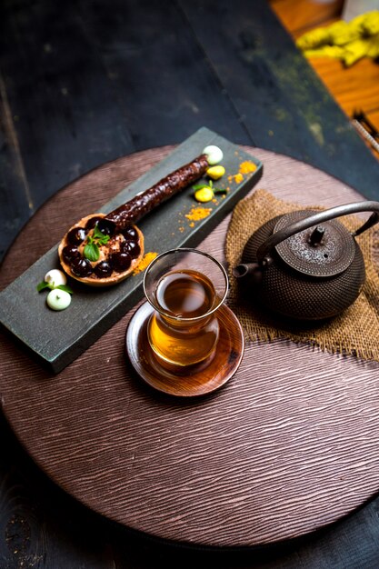 Tea in armudu glass, chinese teapot and chocolate tartaleta