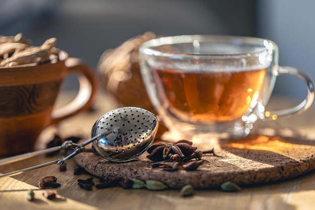 Tea ceremony glass cup of black tea and teapot on blurred home background