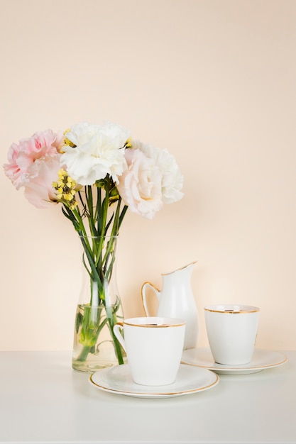 Free photo tea cup next to flower bouquet