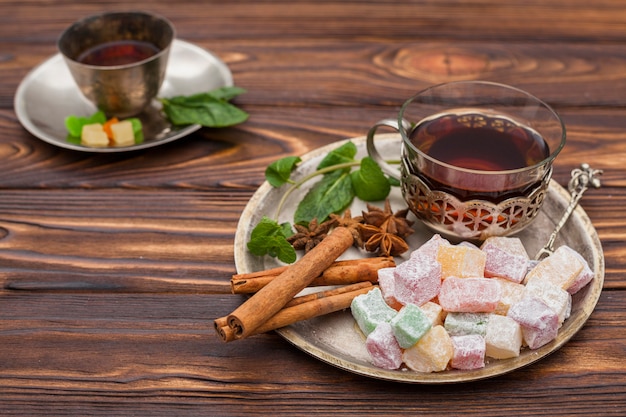 Tea cup with Turkish delight on wooden table