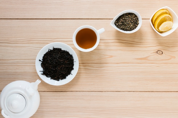 Free photo tea leaves with kettle and lemon slices