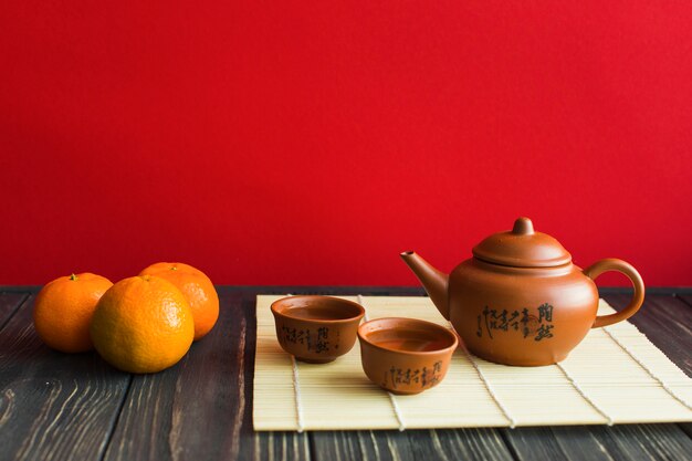 Tea set and tangerines on timber tabletop