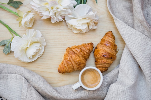 Tea with croissants near beautiful flowers