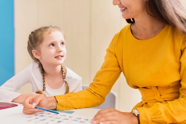 Free photo teacher explaining something to a little girl