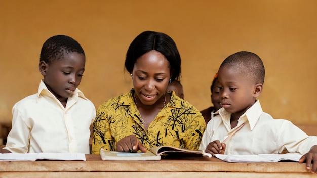 Teacher helping kids in class