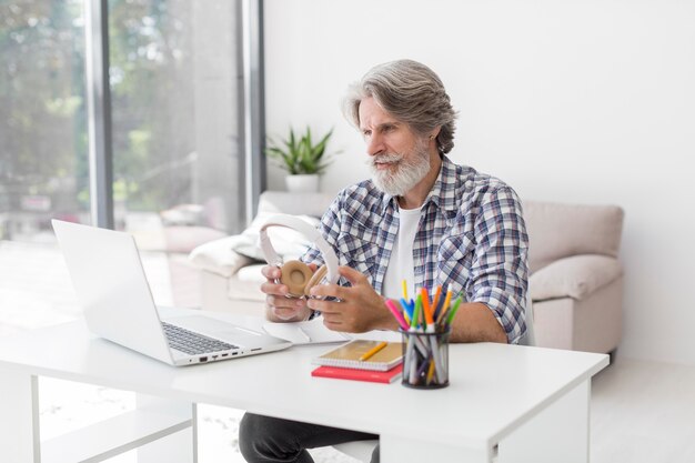 Teacher holding headphones looking at laptop