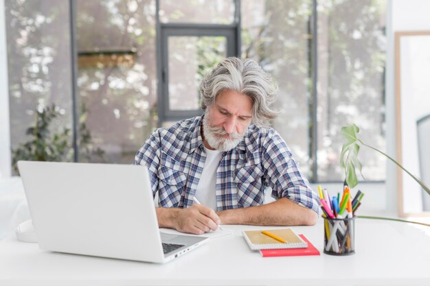 Teacher staying at desk writing on notebook